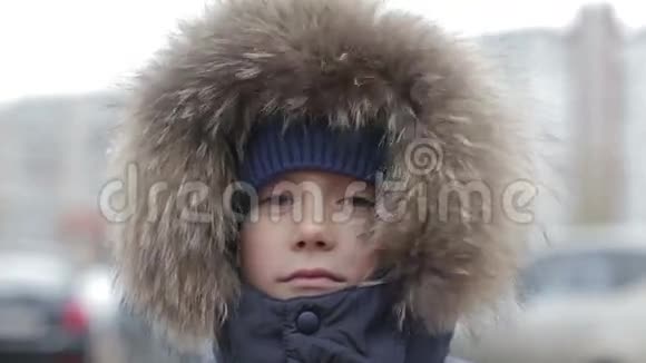 一个穿着冬装头上戴帽子的男孩的肖像视频的预览图