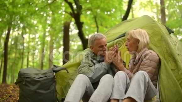 在森林里的帐篷里坐着一对老夫妇视频的预览图