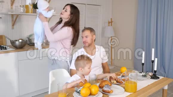 快乐的母亲父亲和儿子在家吃早餐视频的预览图