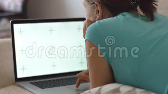 躺在沙发上用笔记本电脑工作的女人视频的预览图