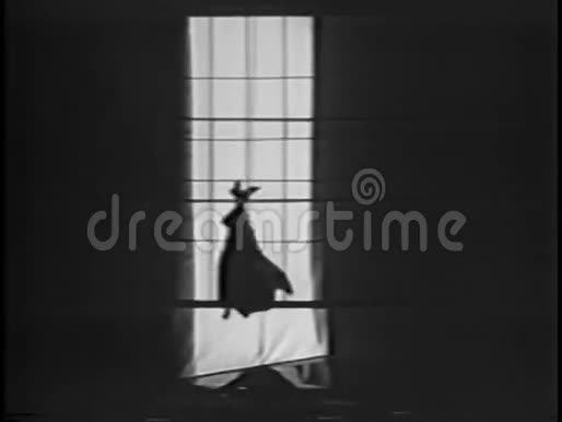 穿着蝙蝠服装的人在窗前爬上绳子视频的预览图