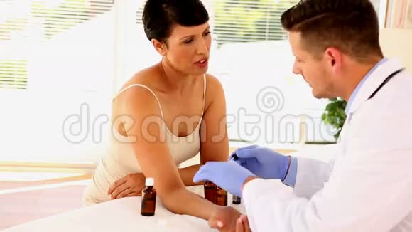 皮肤科医生在妇女手臂上涂软膏视频的预览图