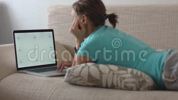 躺在沙发上用笔记本电脑工作的女人视频的预览图