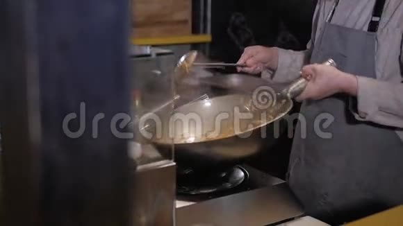厨师用炒锅炒肉炒蔬菜商业厨房烹饪视频的预览图