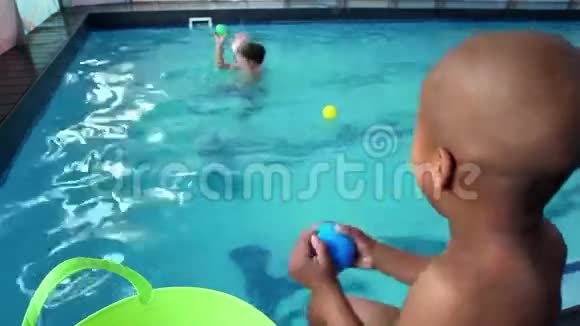 可爱的小男孩在游泳池里玩耍视频的预览图