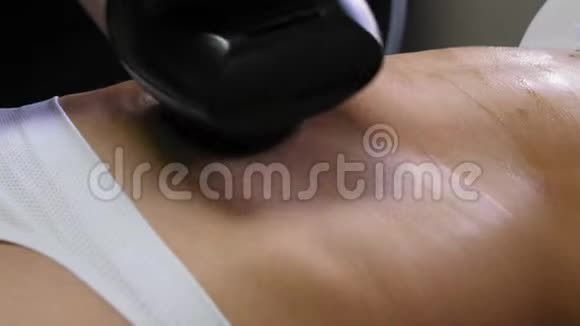 这位瘦女人躺在水疗沙龙时正在用液化石油气工具接受腹部真空按摩Cosmetology视频的预览图