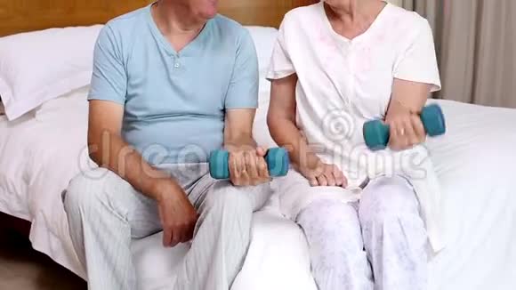 年长夫妇坐在床上举起哑铃视频的预览图