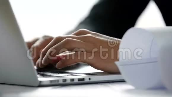 在阳光明媚的日子里在白色的现代办公室里年轻的建筑师用手在笔记本电脑键盘上打字关于视频的预览图