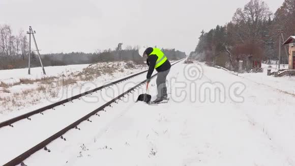 铁路员工在铁路附近清扫积雪并步行离开视频的预览图