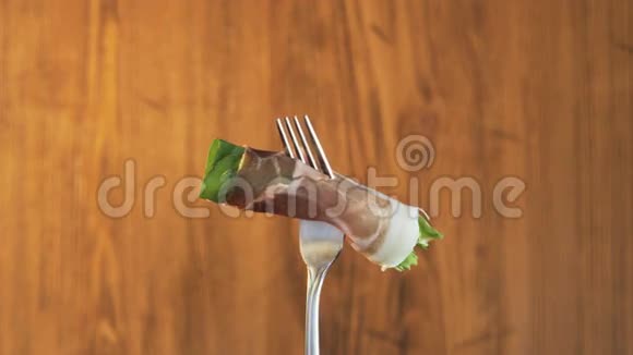 木制背景带火腿和生菜的叉子视频的预览图