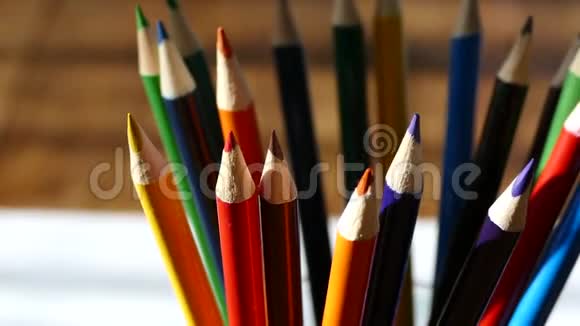 彩色铅笔在一个书写玻璃用彩色铅笔在白纸和木桌上画木制复古桌子视频的预览图