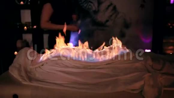 裹着燃烧的毛巾在水疗沙龙里放松的女人的录像中式消防按摩视频的预览图