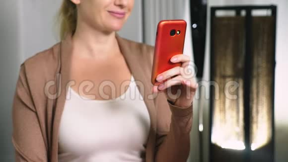 女人用智能手机上的视频交流调情一个女人在视频通话中通过网络发送一个吻视频的预览图