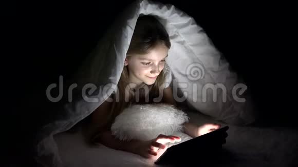 孩子在黑夜里玩平板电脑女孩在床上上网不睡觉视频的预览图