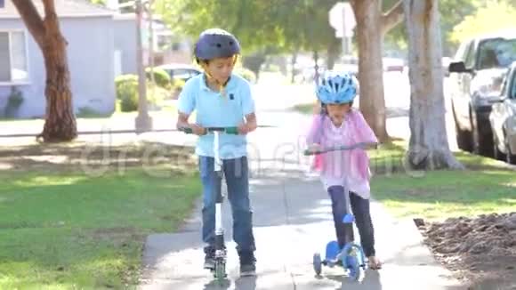 两个孩子骑着滑板车走向镜头视频的预览图