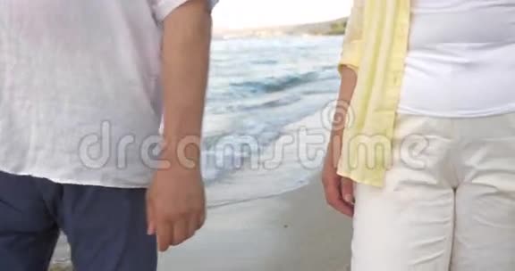 老两口在海滩散步时牵手视频的预览图