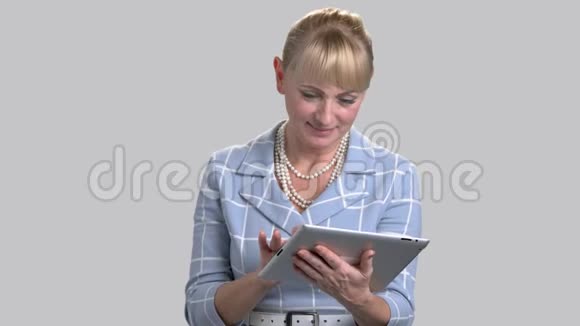 成熟的商业女性与平板电脑视频的预览图