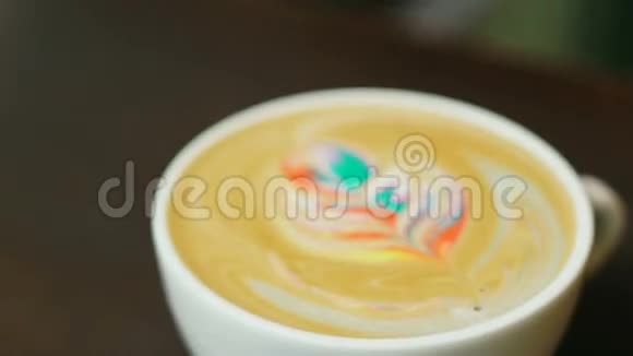 拉丁艺术咖啡五颜六色的彩虹拿铁在白色的杯子里视频的预览图