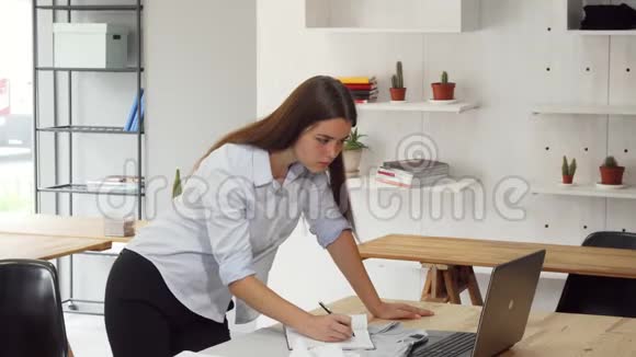 女设计师在办公室忙着用她的笔记本电脑视频的预览图