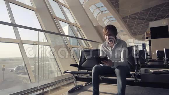 英俊的微笑男人拿着平板电脑在机场工作技术旅游和现代生活理念视频的预览图