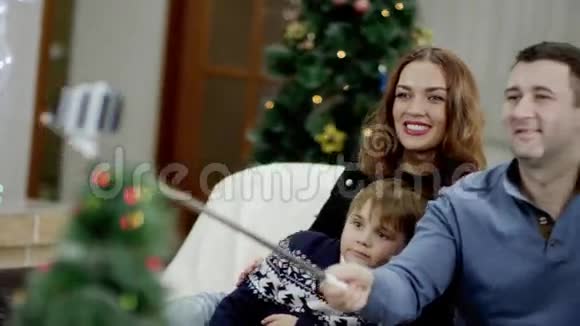 圣诞派对中一家人带着自拍棒在家自拍视频的预览图