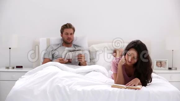 女人在看书而伴侣在看报纸视频的预览图