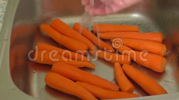 女人在厨房水槽里洗胡萝卜视频的预览图