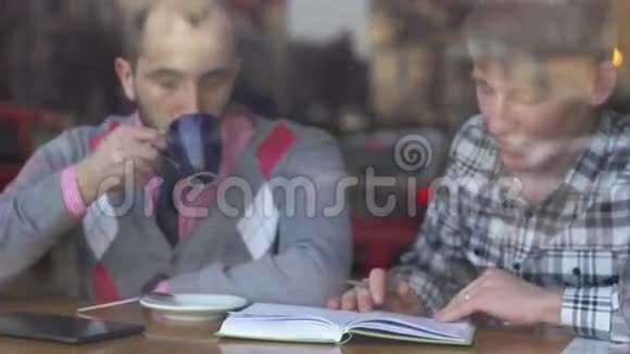 两个年轻人在咖啡馆里创意会议视频的预览图