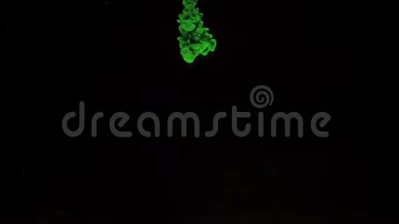 彩色的绿色墨水从上面的水中混合而来在黑色背景下轻轻地旋转带有复制空间视频的预览图