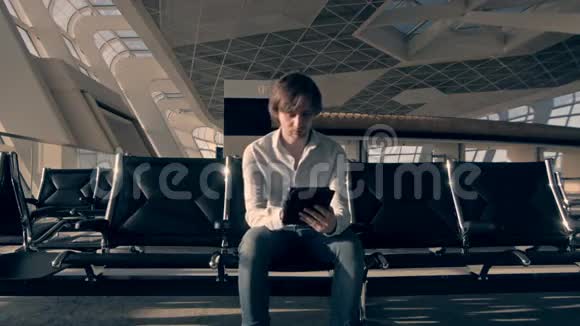 英俊的微笑男人拿着平板电脑在机场工作技术旅游和现代生活理念视频的预览图