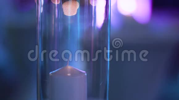 玻璃杯下白色装饰蜡烛被打火机点燃的细节镜头视频的预览图