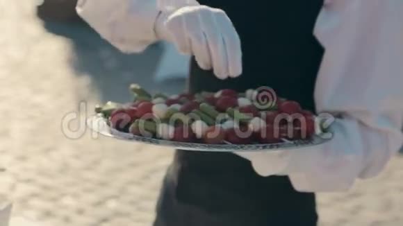 服务员把装有樱桃番茄和奶酪的罐头放在餐盘上视频的预览图