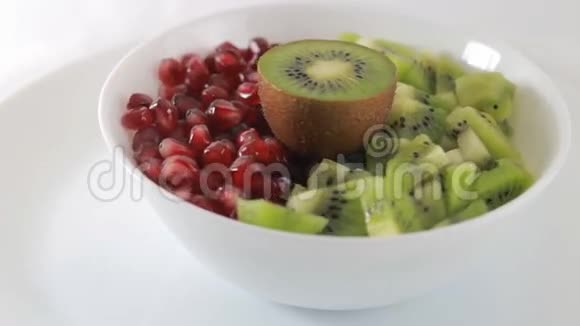 猕猴桃和石榴放在白色盘子里水果沙拉原料视频的预览图