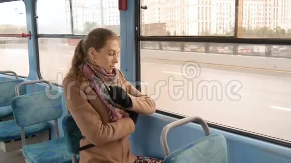 一个美丽的女孩带着悲伤的眼睛坐在电车里视频的预览图