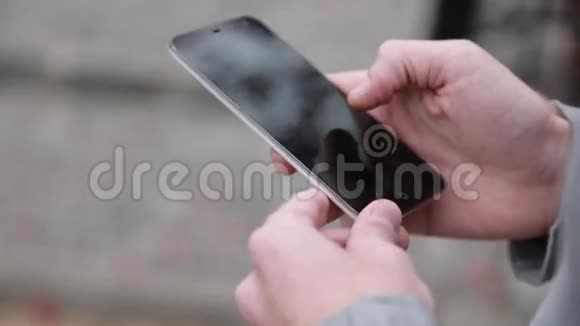 一个手里拿着手机智能手机的男人视频的预览图