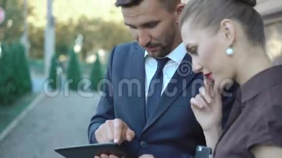 男人和女人在户外使用平板电脑4K视频的预览图