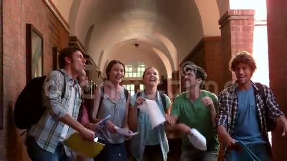 快乐的学生在走廊的空中跳跃视频的预览图