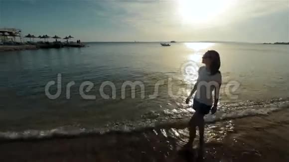 年轻女孩沿着海滩日落或视频的预览图