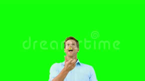 一个人在绿色屏幕上用嘴捕捉橙色片段视频的预览图