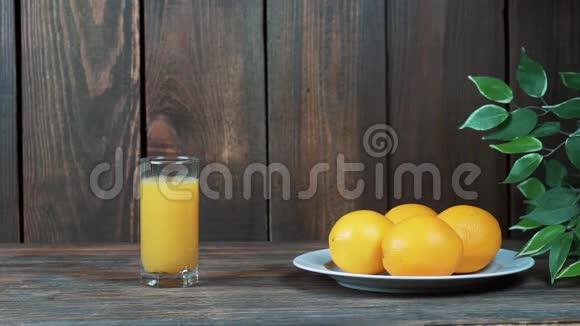 一杯鲜榨橙汁倒挤橙汁在木制背景上视频的预览图