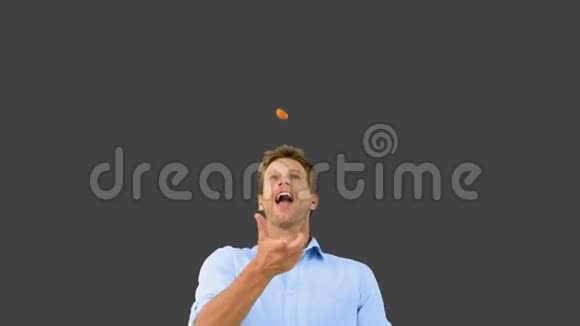 一个人用嘴在灰色屏幕上捕捉橙色片段视频的预览图