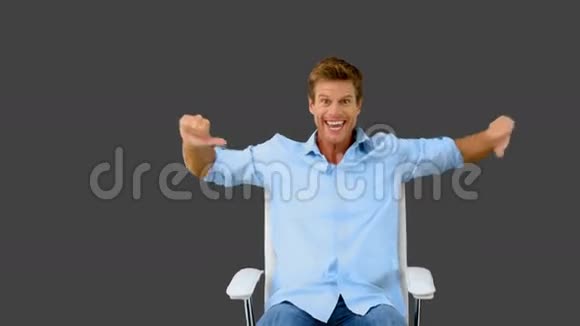 坐在转椅上的人在灰色屏幕上竖起大拇指视频的预览图