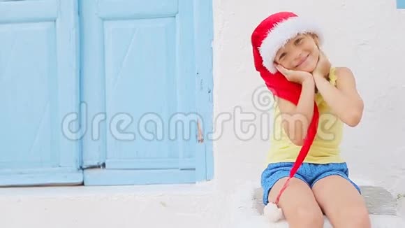 戴红帽子的小女孩在迈科诺斯的老街上典型的希腊传统村落白人街上的孩子视频的预览图