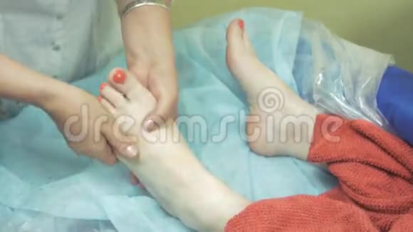 在酒吧为成年妇女按摩左脚红色的指甲治疗视频的预览图