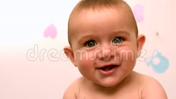 婴儿坐在婴儿床上对着镜头微笑视频的预览图