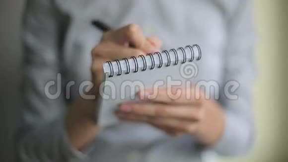 手写女人在笔记本上写笔视频的预览图