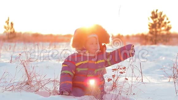 快乐的孩子在日落时在雪地里玩耍视频的预览图
