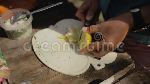 女人把柠檬切成薄片在森林的篝火上煮食物营地生活旅行视频的预览图