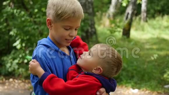 小婴儿温柔地拥抱和亲吻他的哥哥男孩拥抱弟弟视频的预览图