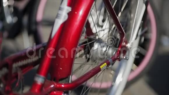 在夏天阳光明媚的日子里坐在红色自行车的后轮上关门视频的预览图